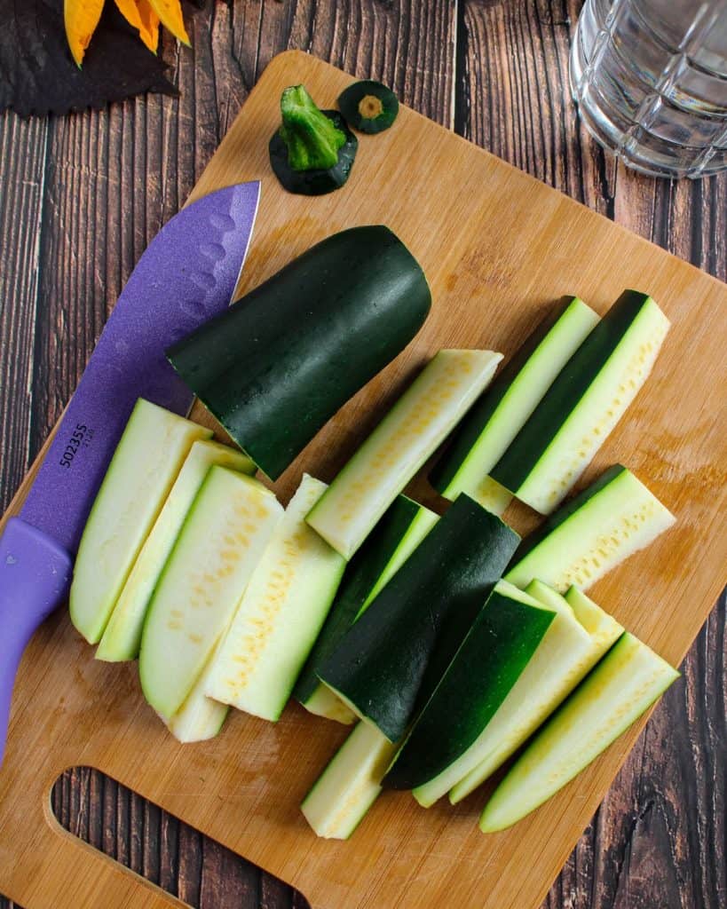 Slicing zucchini into wedges. 