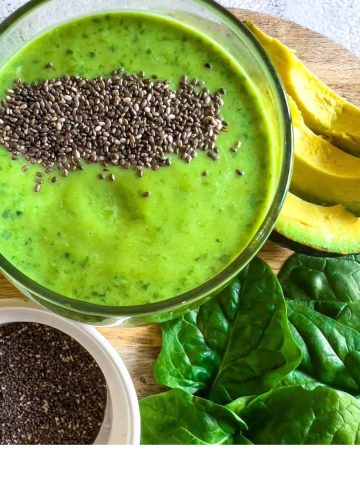 An avocado spinach smoothie on a table.