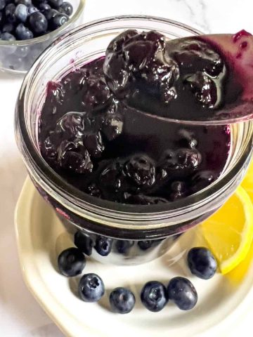 Blueberry jam in jar and spoon.