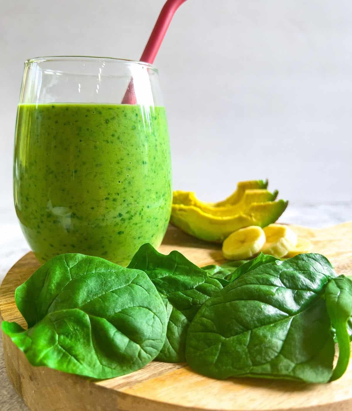 Delicious avocado spinach in a glass with ingredients.
