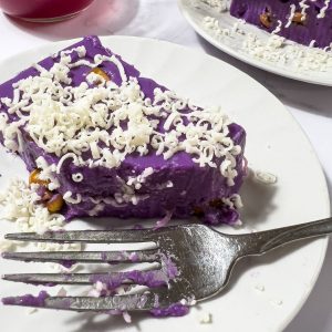A bite of ube maja blanca with cheese on top.