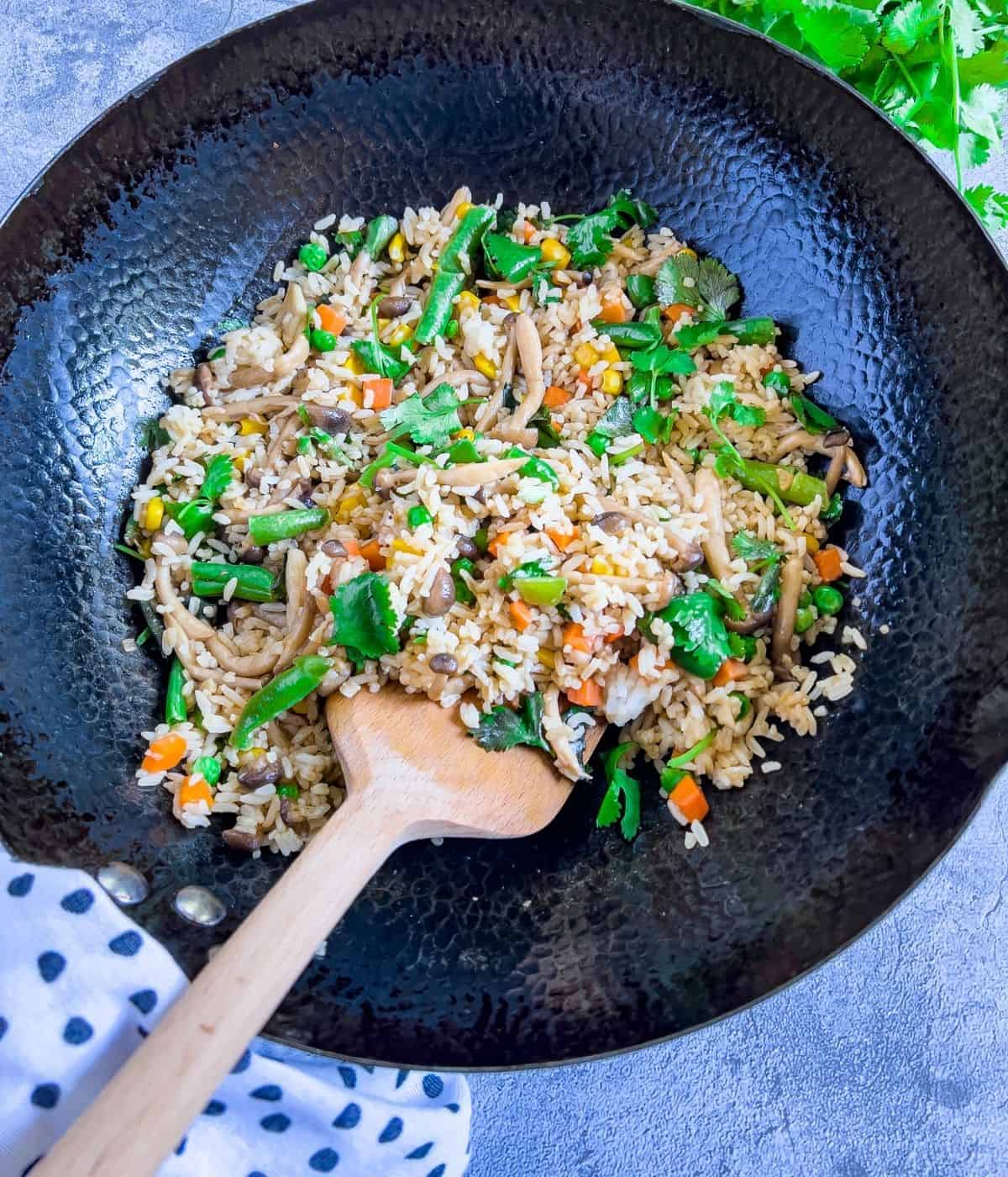 Mushroom vegetable fried rice in a wok.