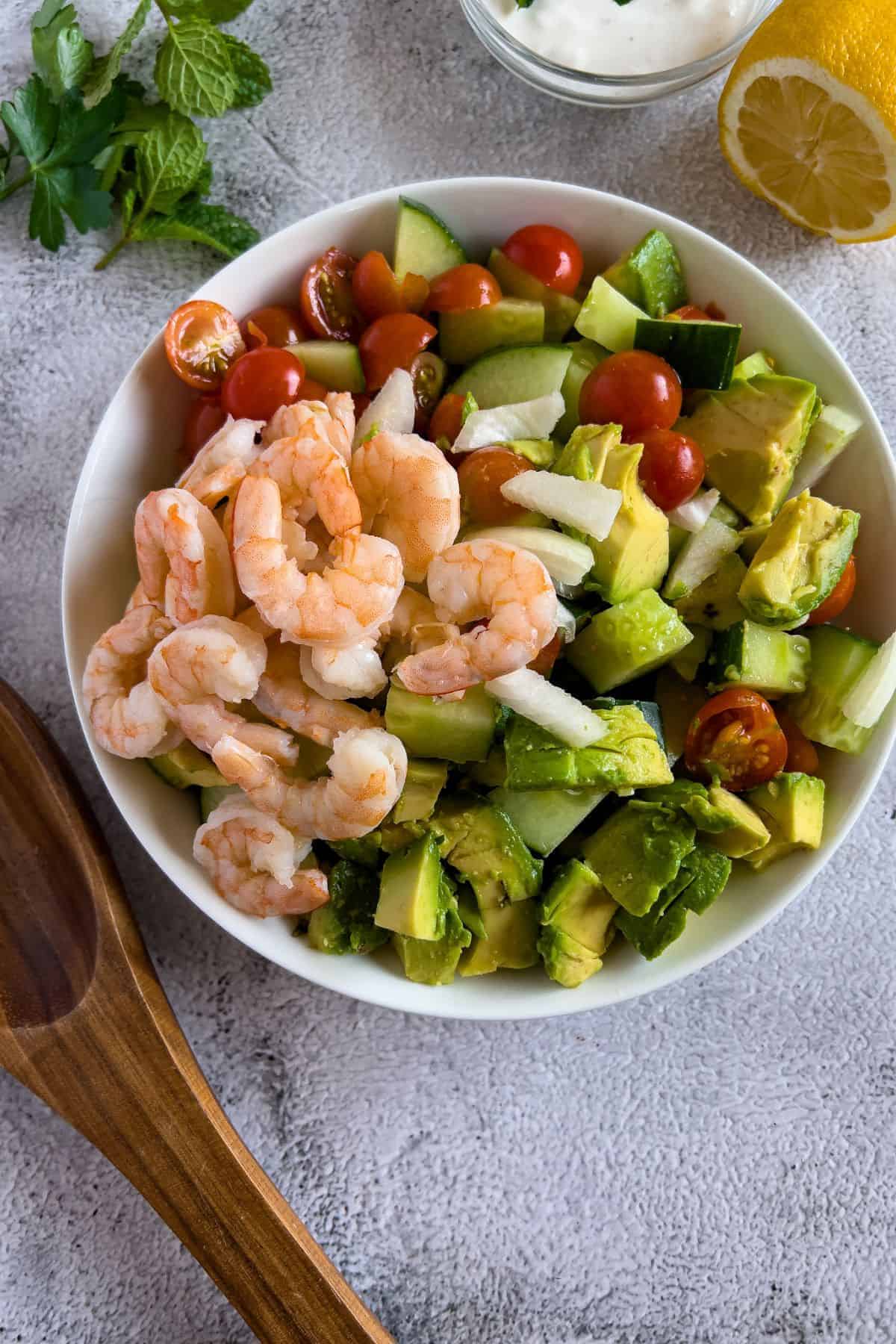 Combining all the ingredients for the shrimp avocado summer salad.