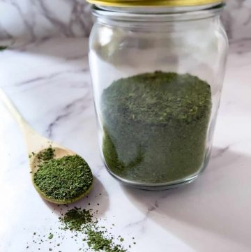 Swiss chard green powder in a mason jar and spoon.