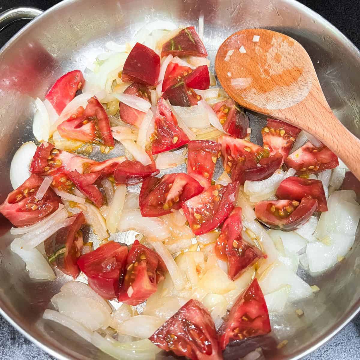 Saute onion, garlic, and tomatoes in skillet.