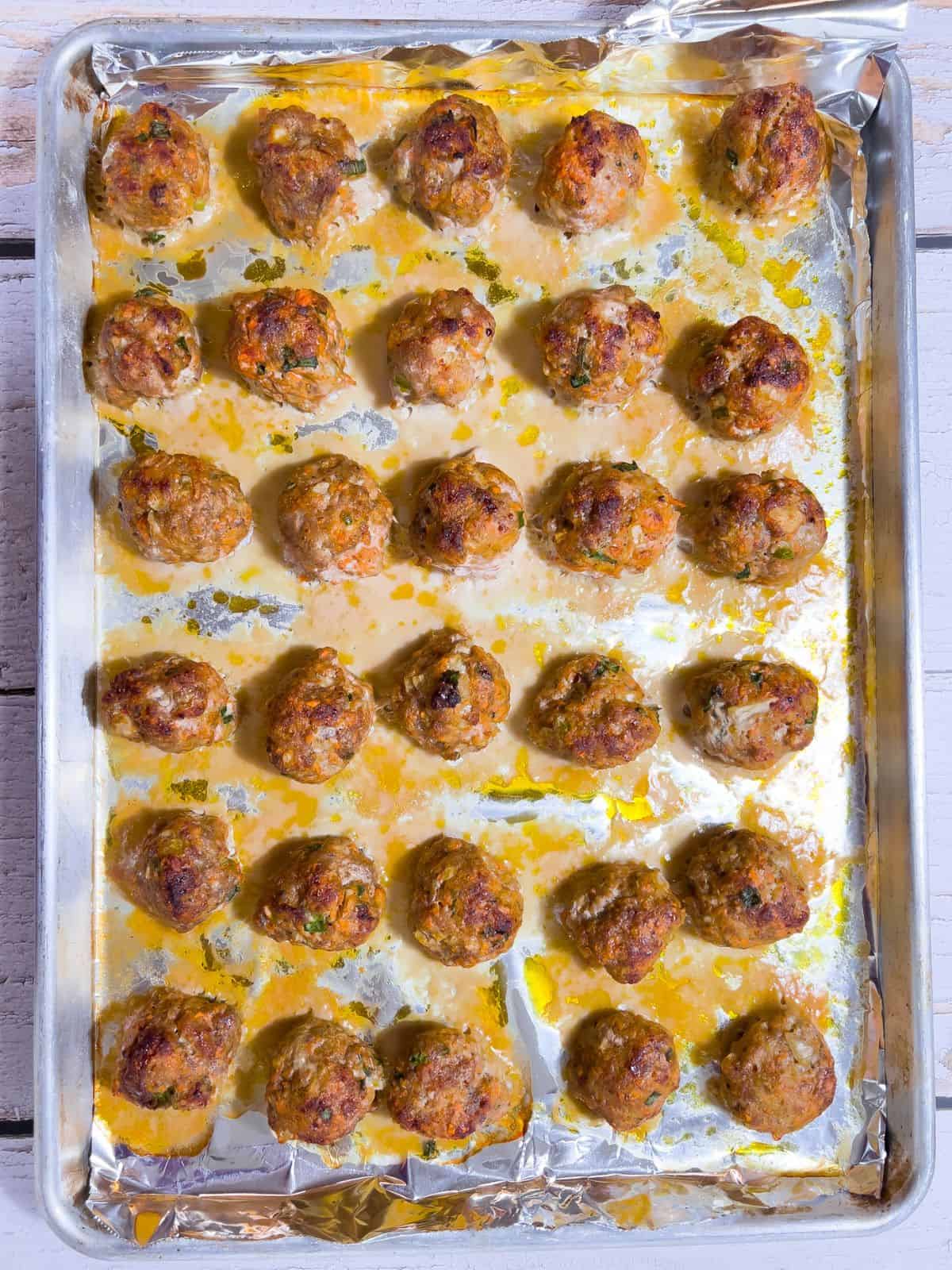 Baked turkey and sausage meatballs on a tray.