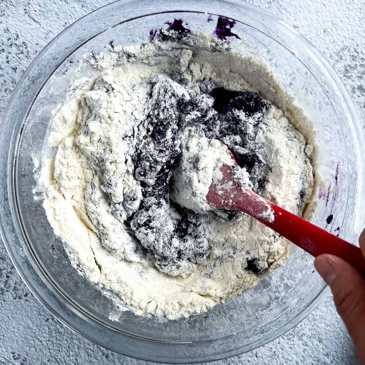 Combining dry and wet ingredients to make an ube cookie dough.