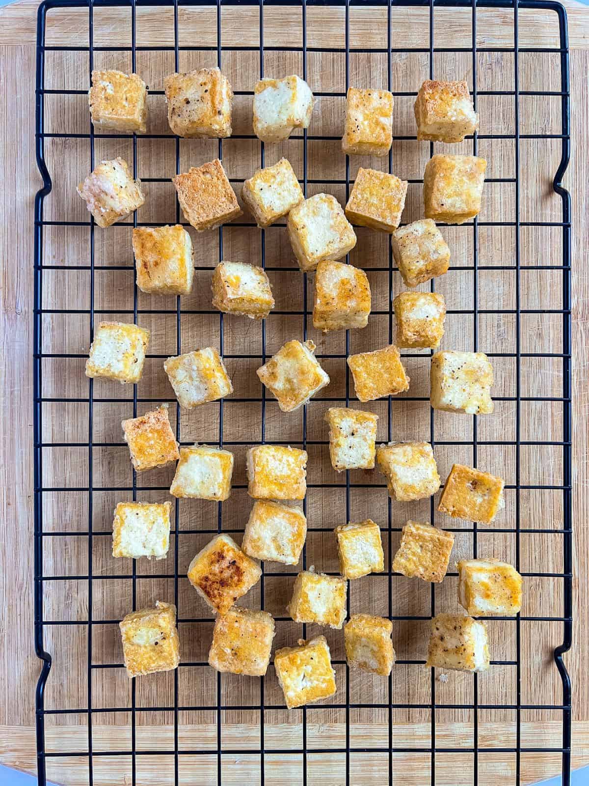 Fried tofu in a cooling wire rack.