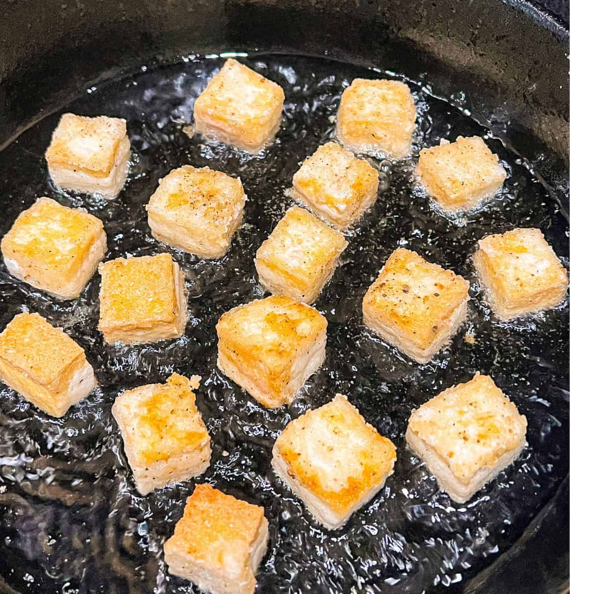 Frying tofu in a skillet.