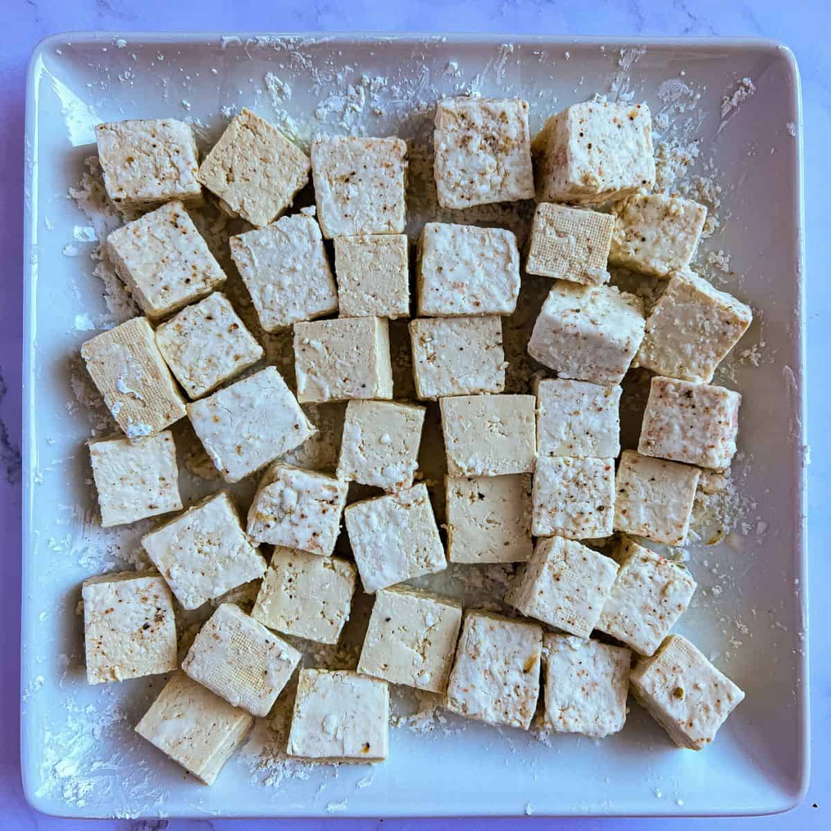 Tofu cubes coated in cornstarch mixture.