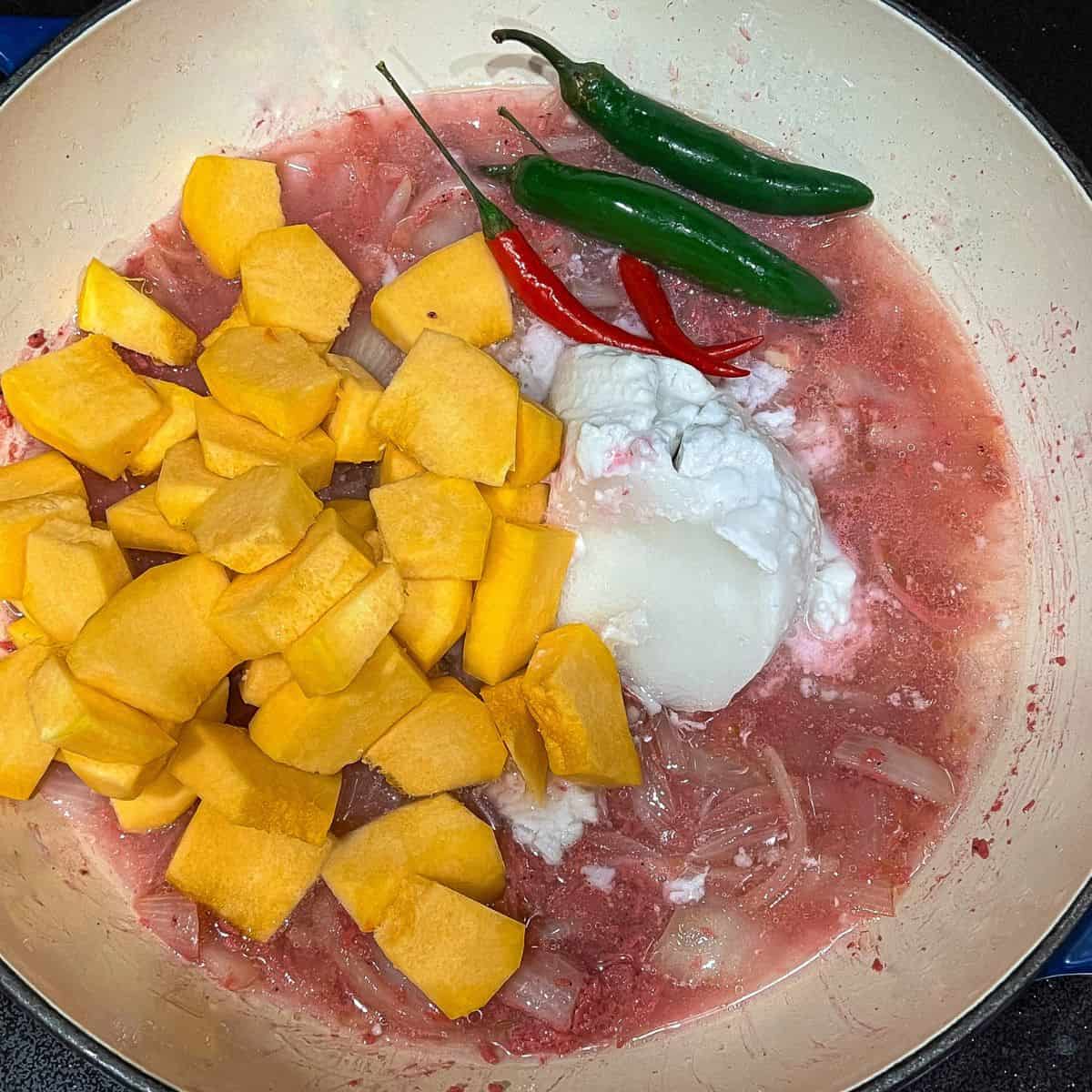 Add squash, coconut milk, red and green chili peppers, and cook.
