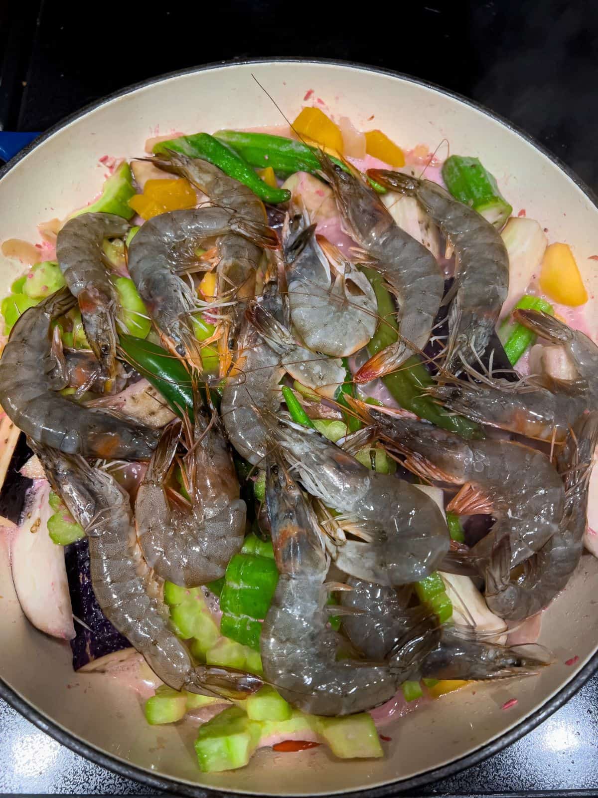 Adding the shrimp to cook the dish.