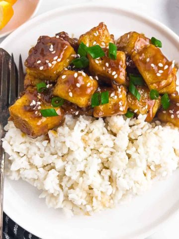 Serving orange chicken dish on a plate, ready to eat.