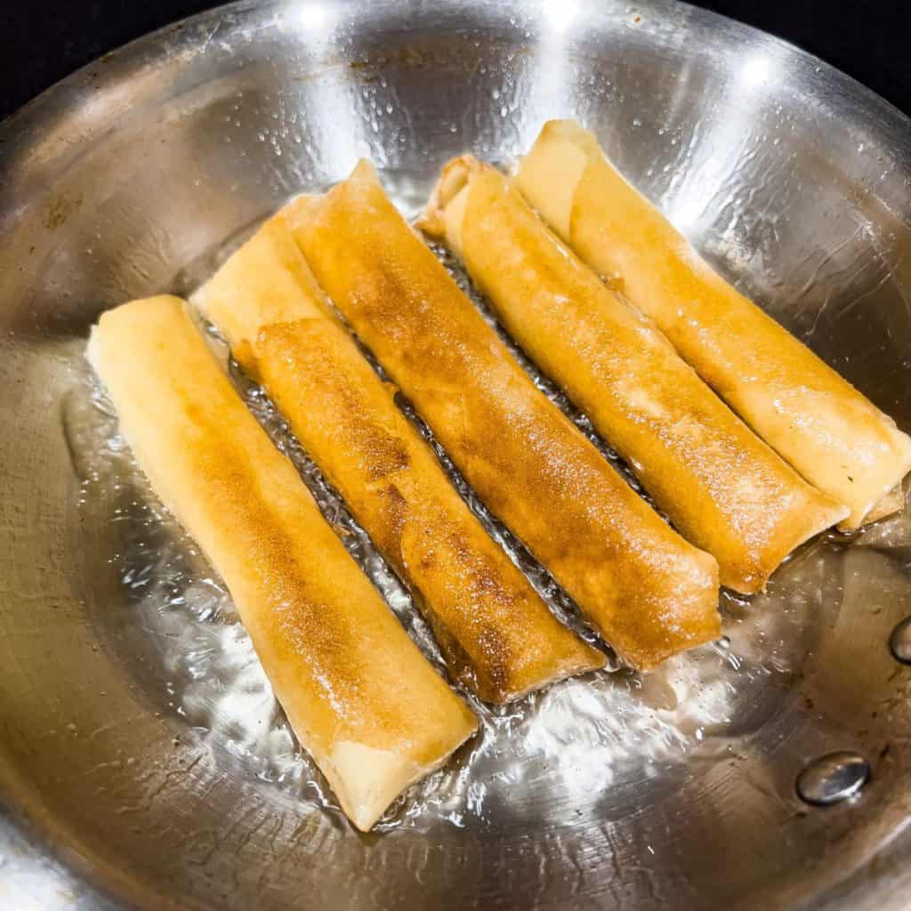 Frying cheese lumpia.