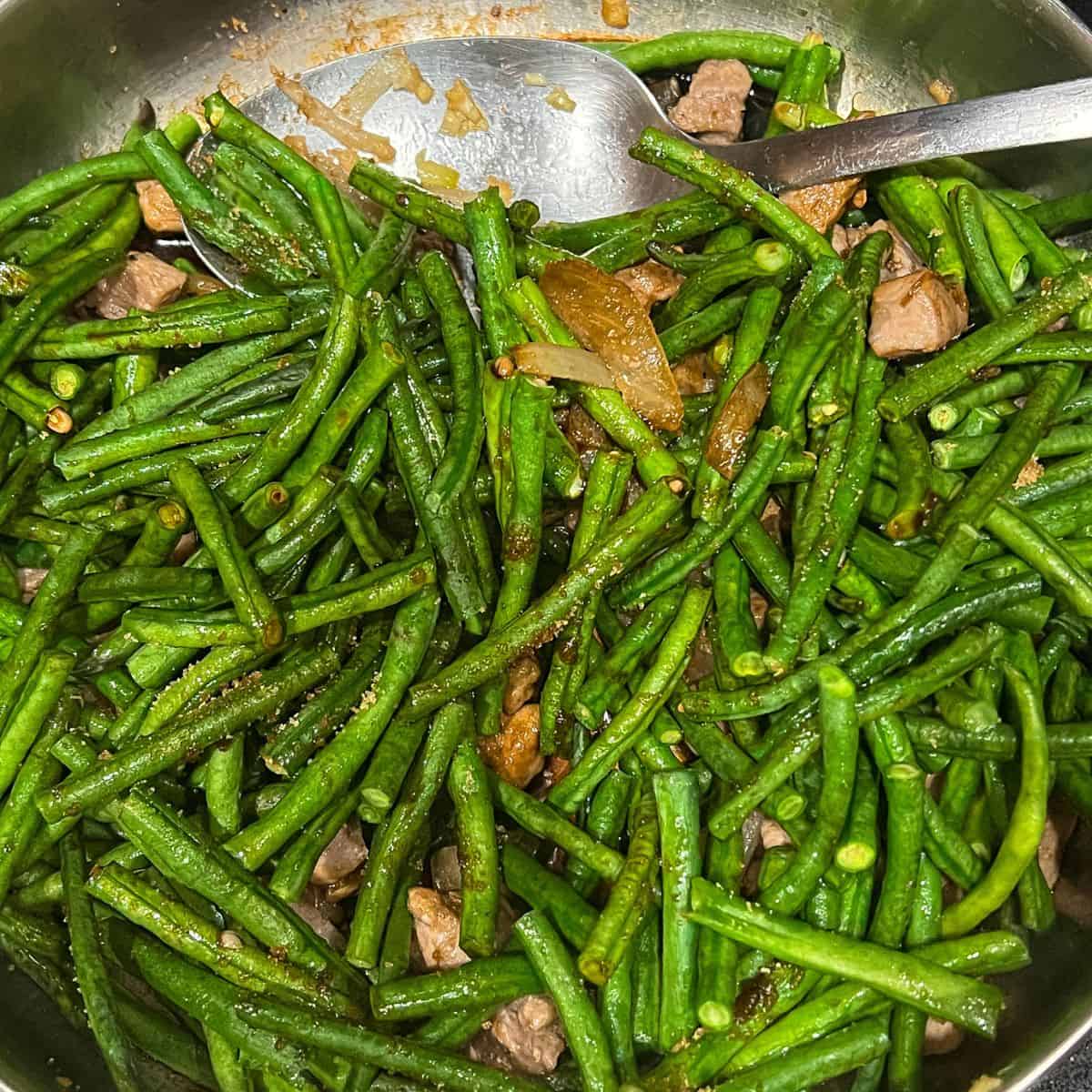 Adding string beans, soy sauce, and brown sugar. Toss to combine.