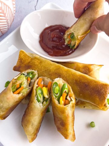 Finish dish of crispy vegetable lumpia with a dipping sauce.