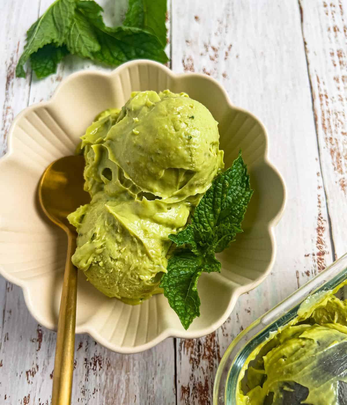 Keto avocado ice cream in a bowl with spoon.