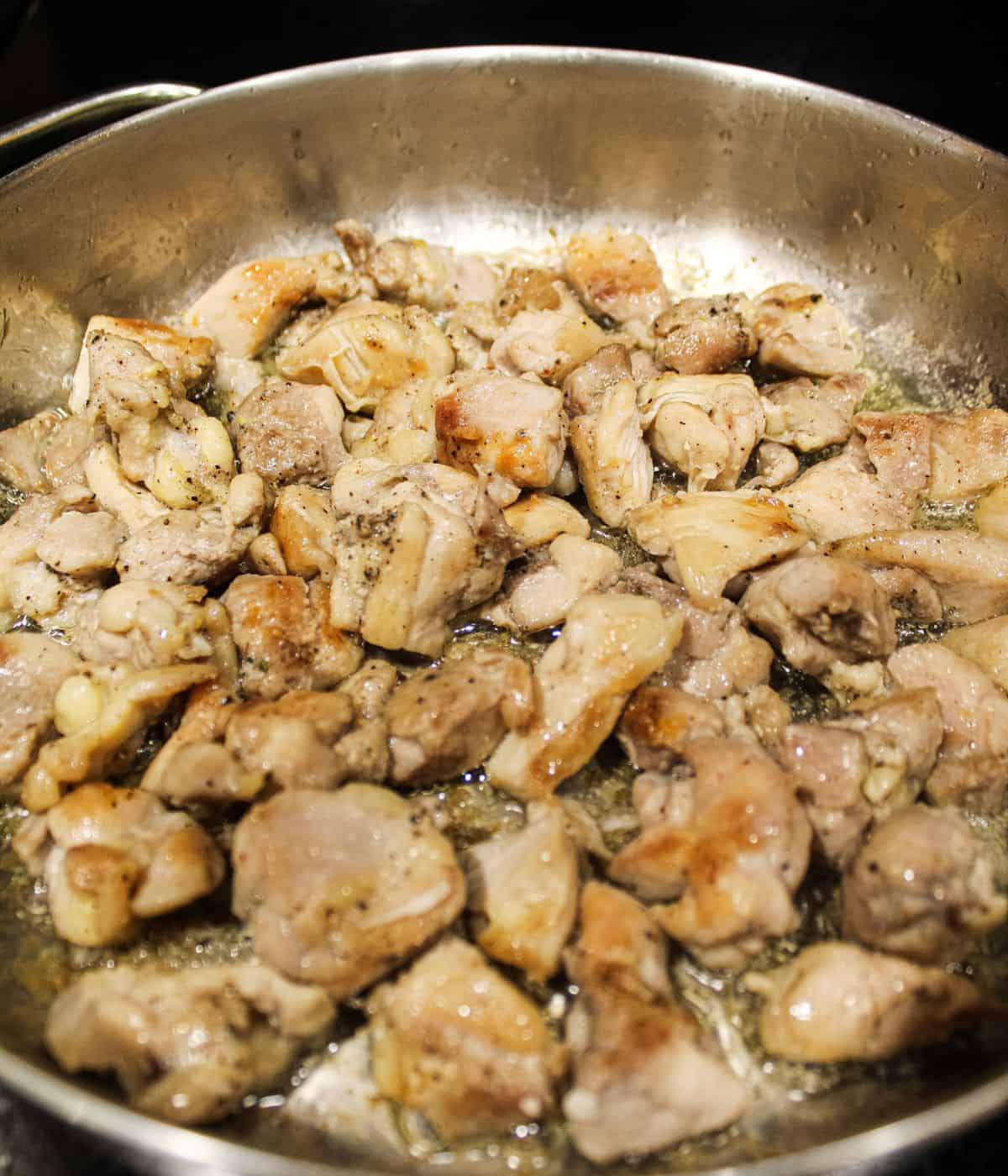Seared chicken in skillet.