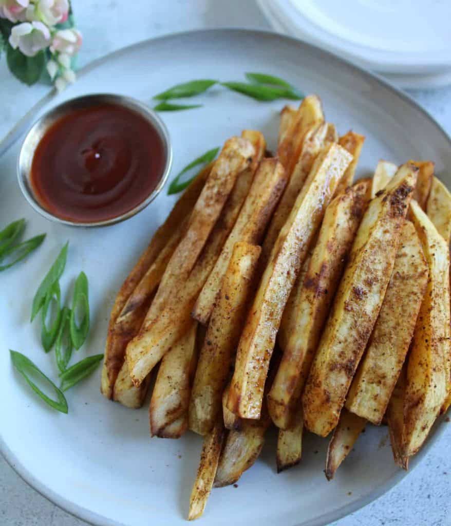 Finish dish of sweet potato french fries in a plate with dipping sauce.