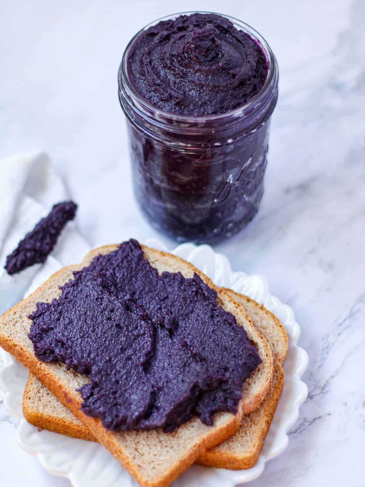 Ube jam in a jar and spread in a slice bread.