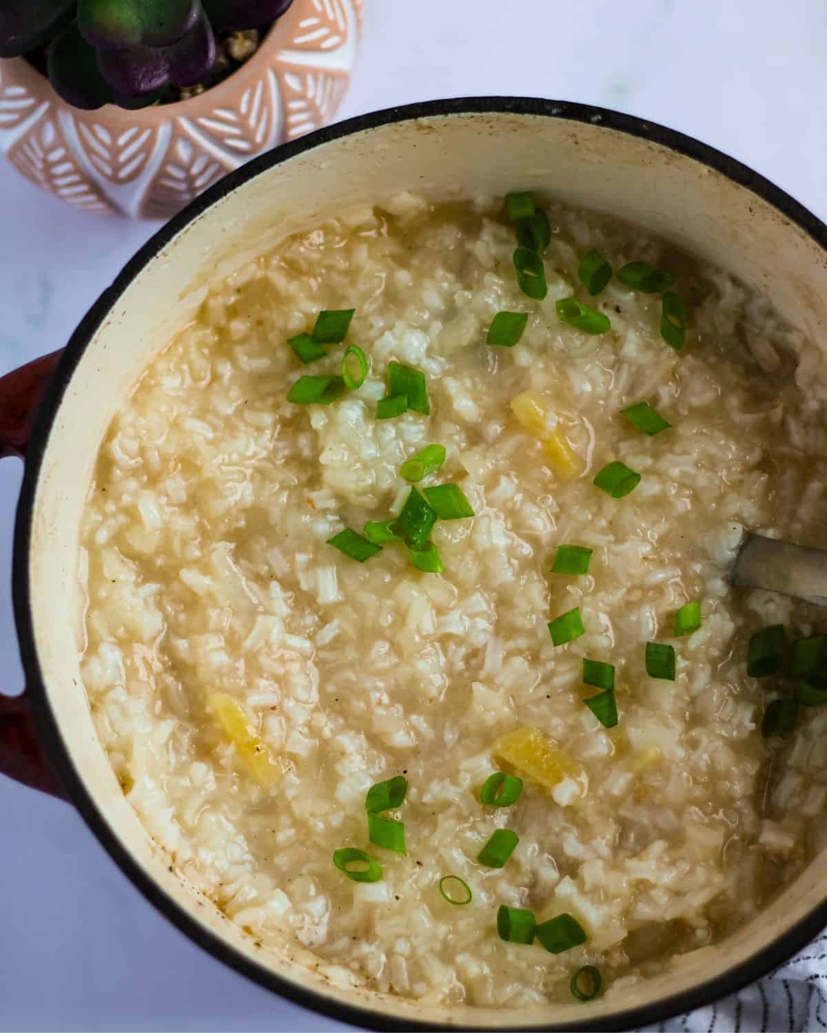 Finish dish of arroz caldo without chicken in a dutch oven with green onions.