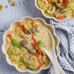Finish dish of pork sopas in a bowl with spoon.