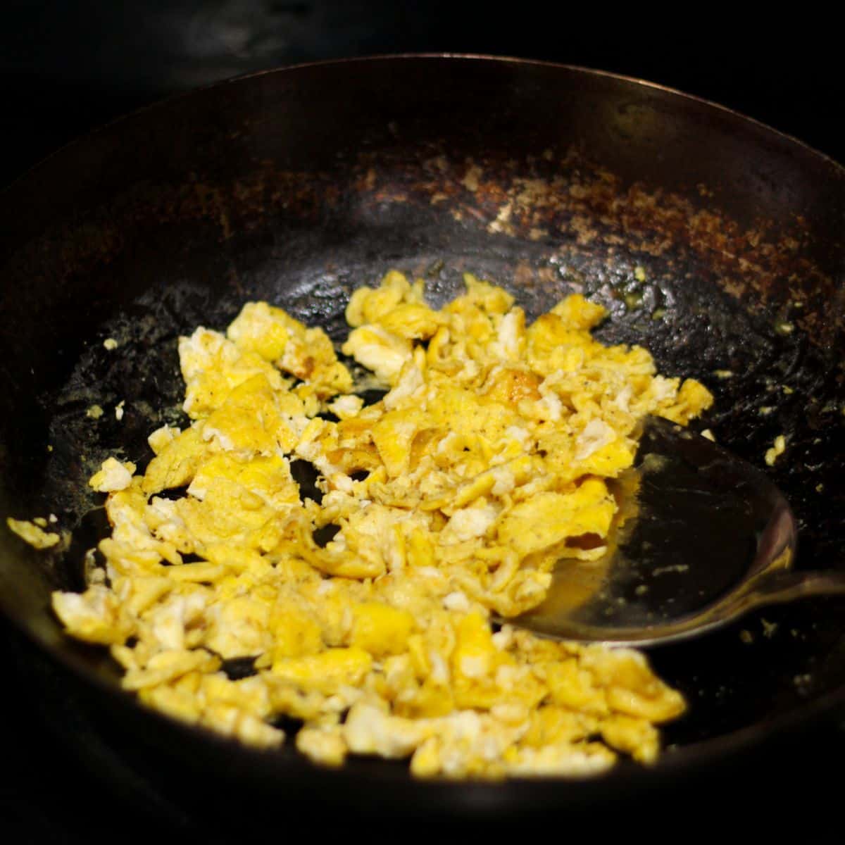 Scrambling eggs in a wok.
