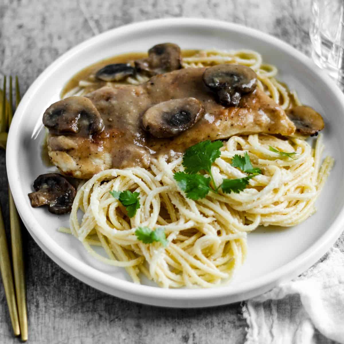 Finish dish of chicken marsala in a plate with pasta.