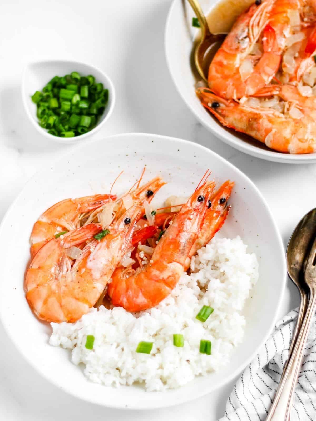 Finish dish of butter garlic shrimp with sprite in a table with rice.