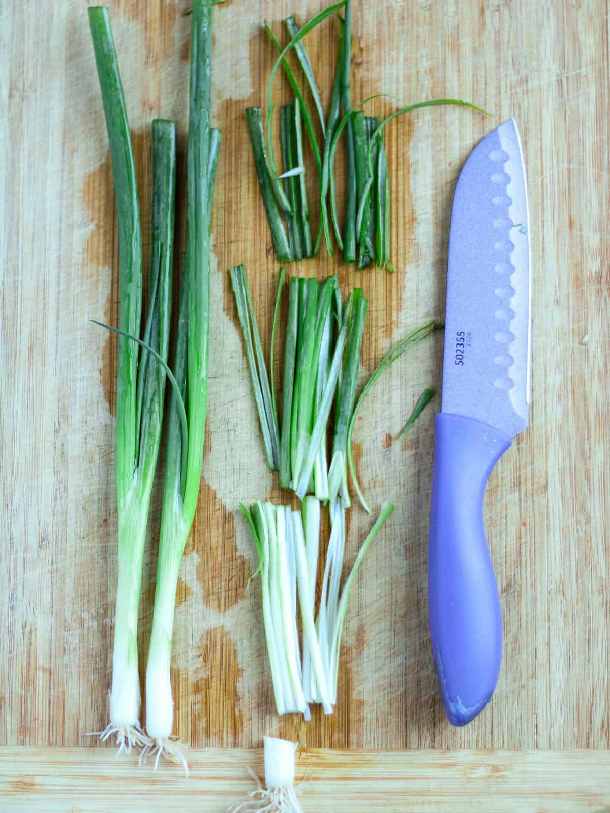 Cutting green onion to make salad.