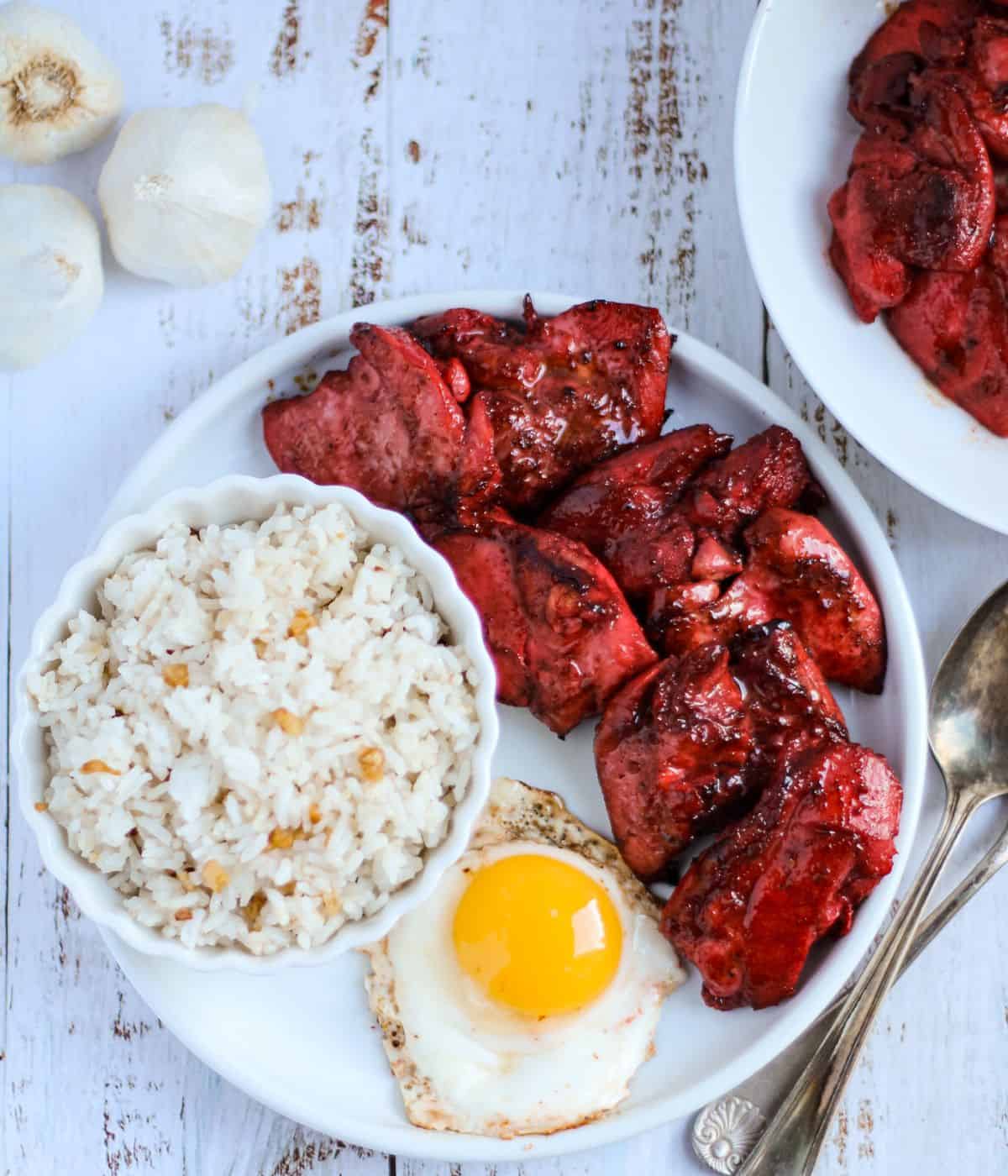 Tocino, fried rice and fried egg in a plate.