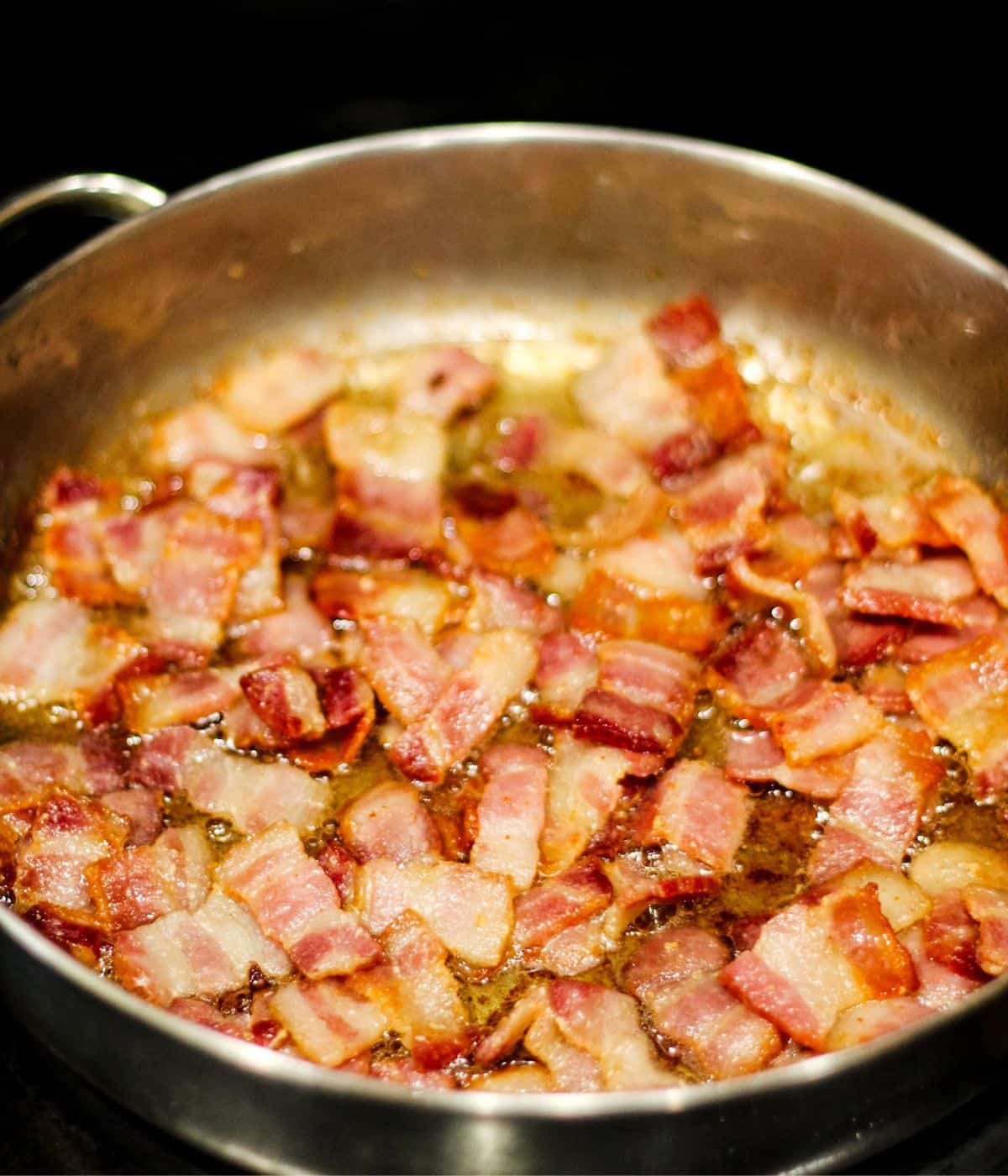 Cooking the bacon until golden brown and crispy.