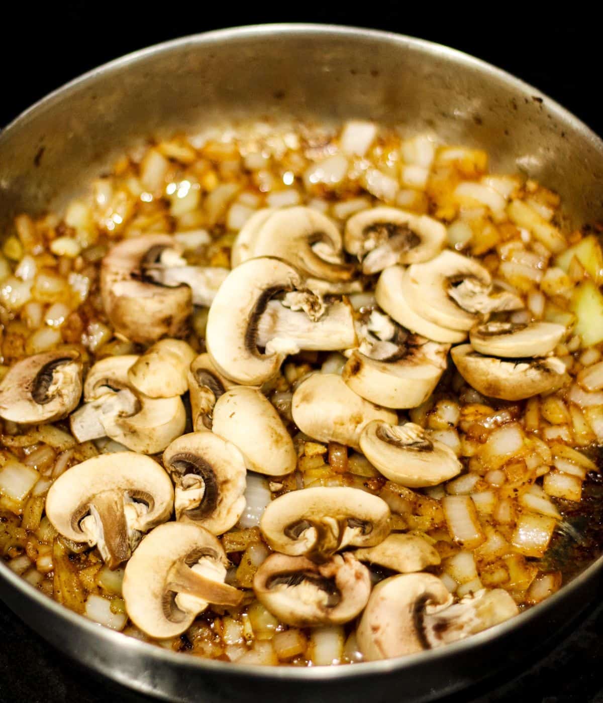 Adding mushrooms in a skillet.