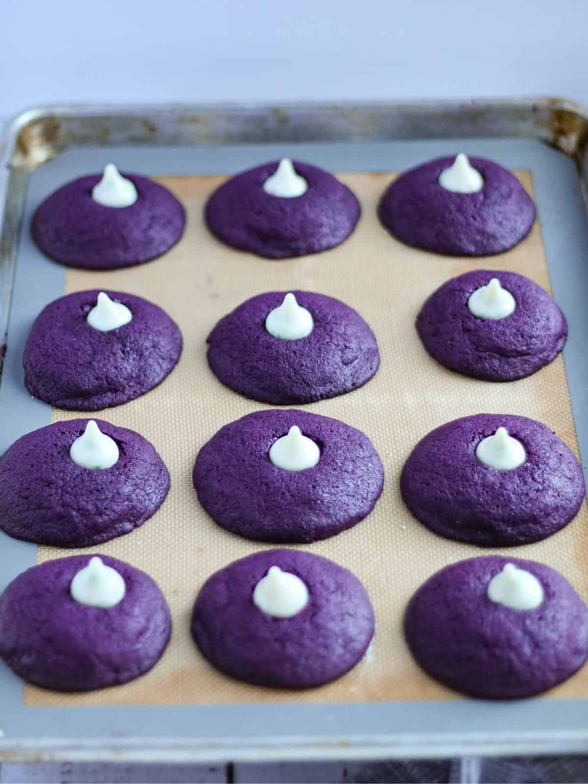 Baked ube cookies with hershey kisses on top.