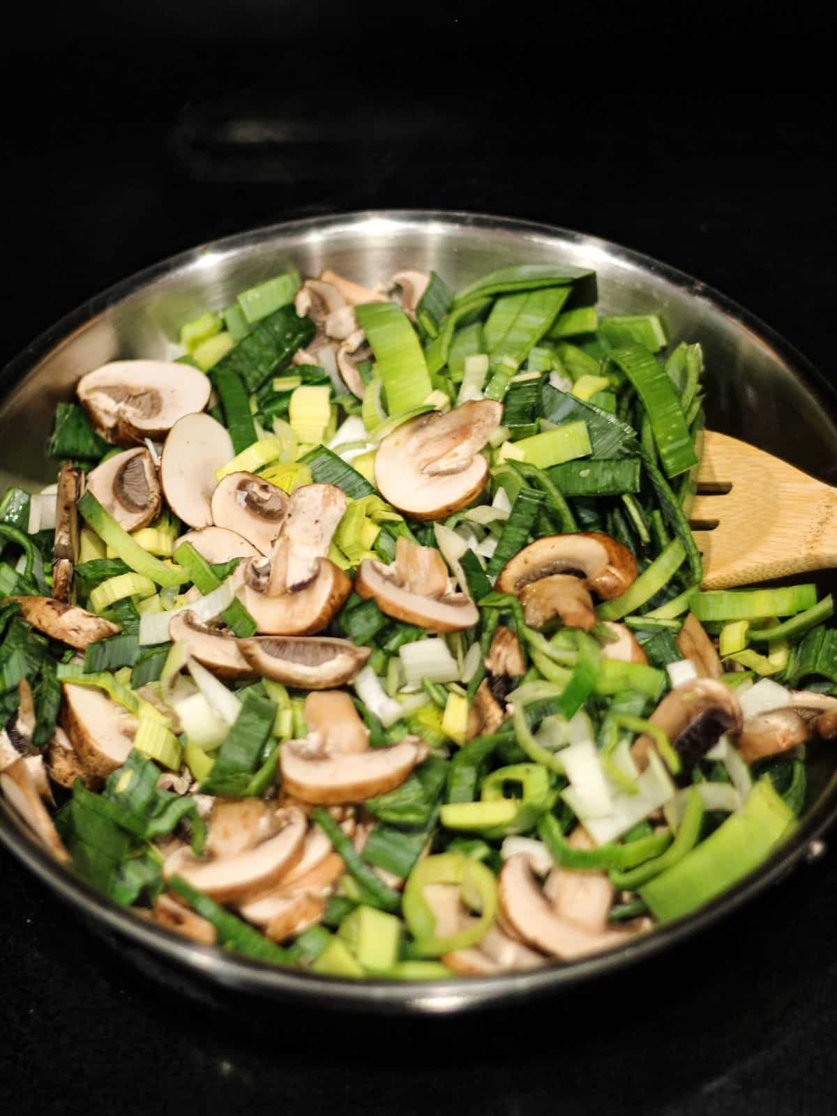 Sauteing garlic, leek, and mushrooms in a skillet.