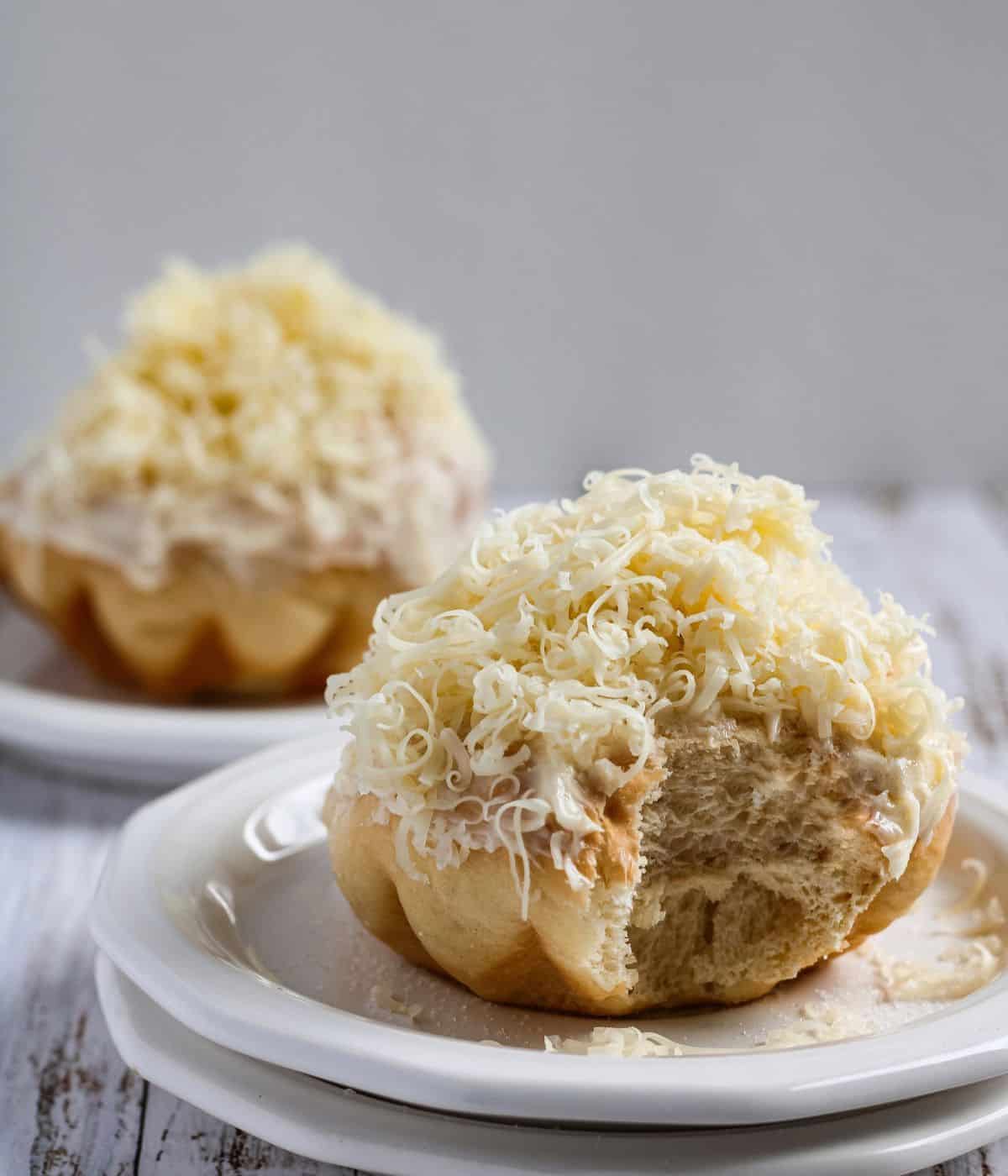 Ensaymada in a plate with a bite.