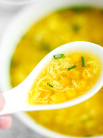Sweet corn egg drop soup in a spoon.