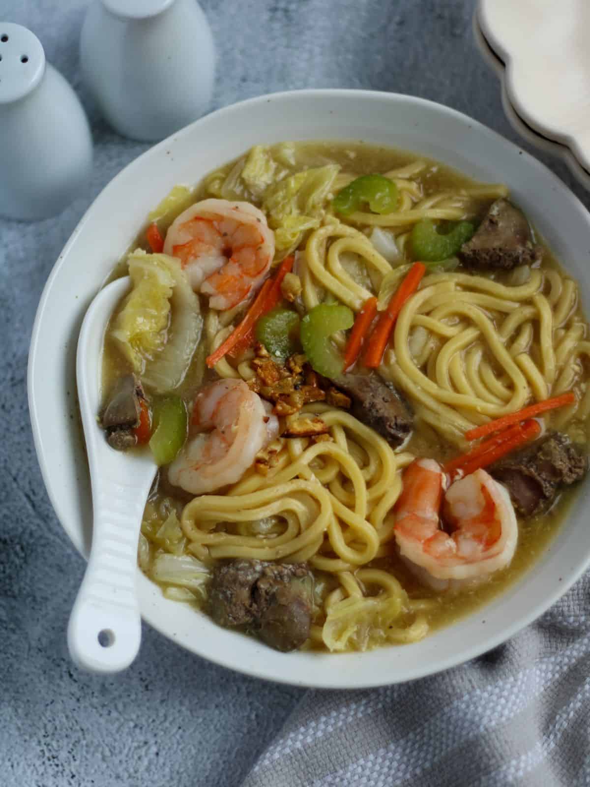 Pancit lomi in a bowl with spoon.