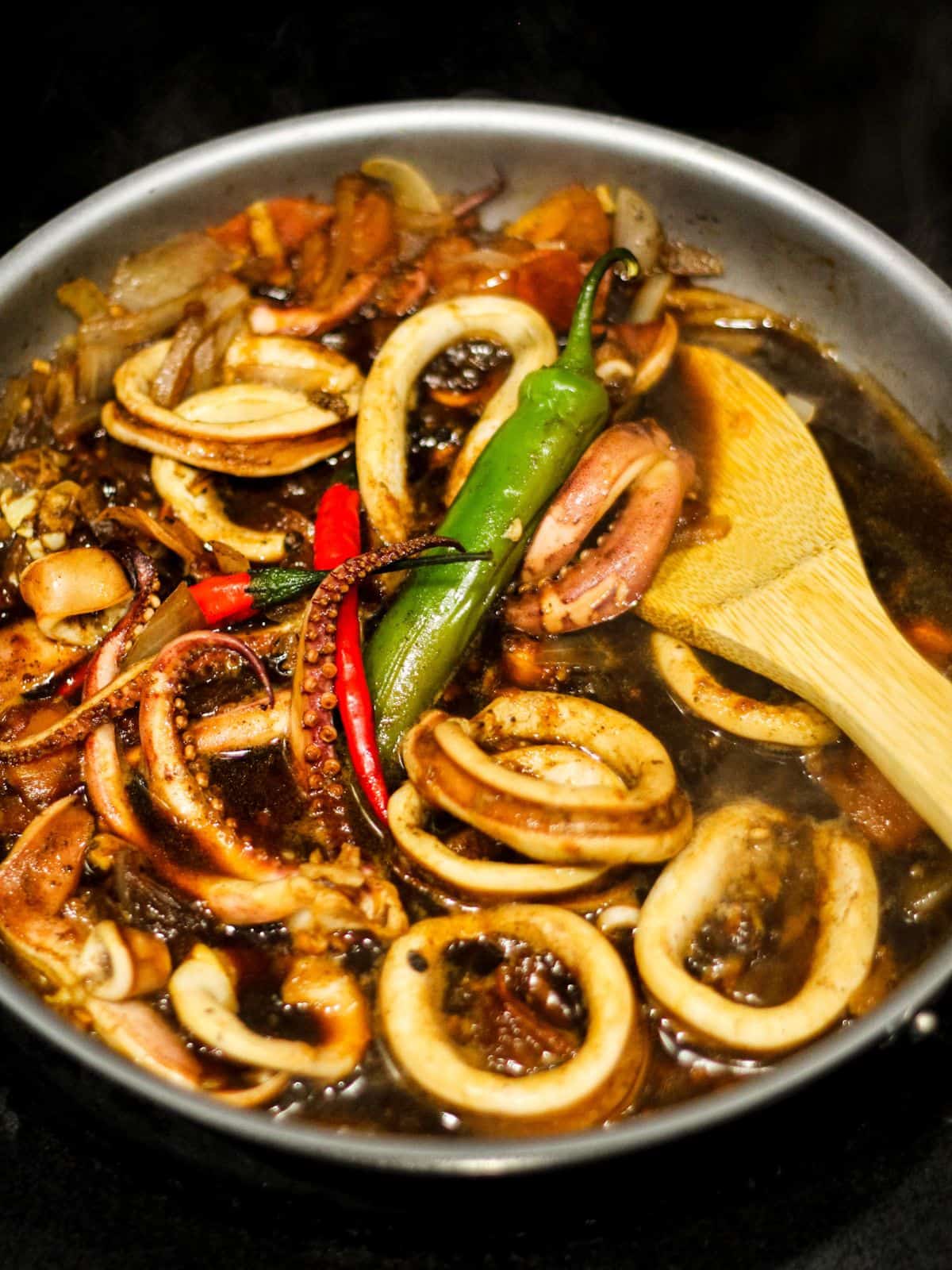 Cooking squid adobo in a skillet.