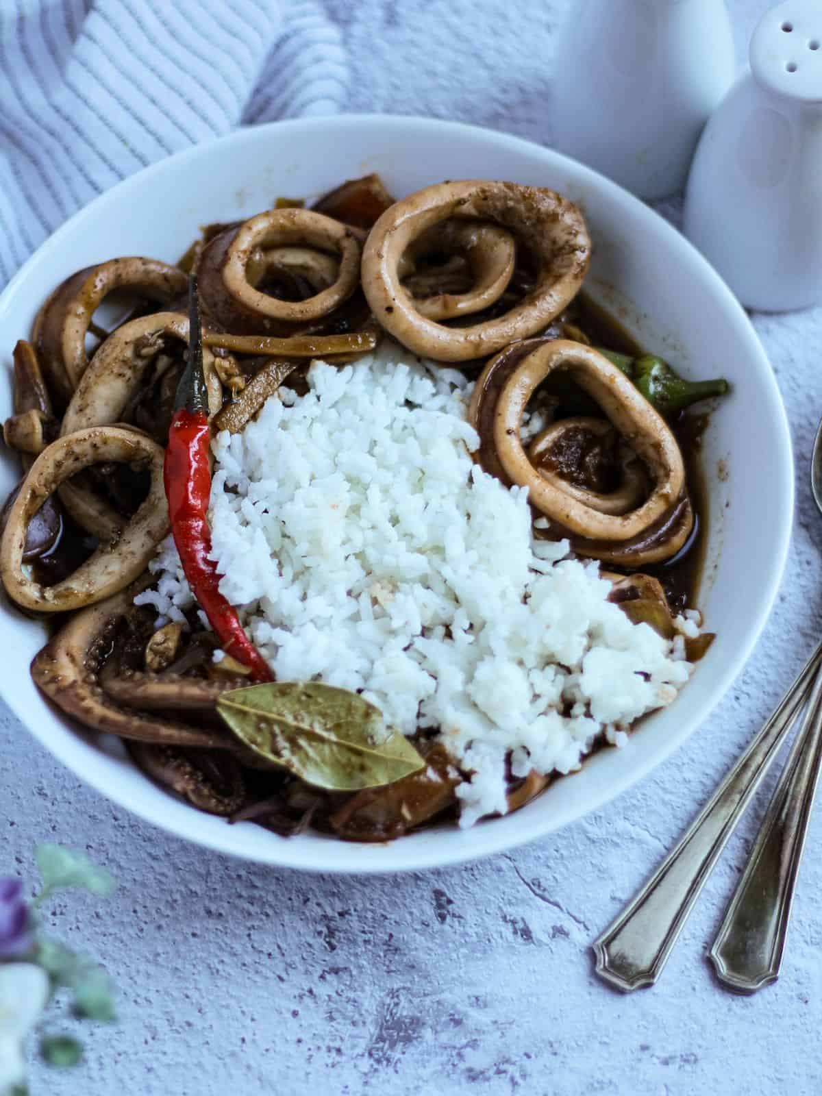 Squid adobo with rice in a plate.