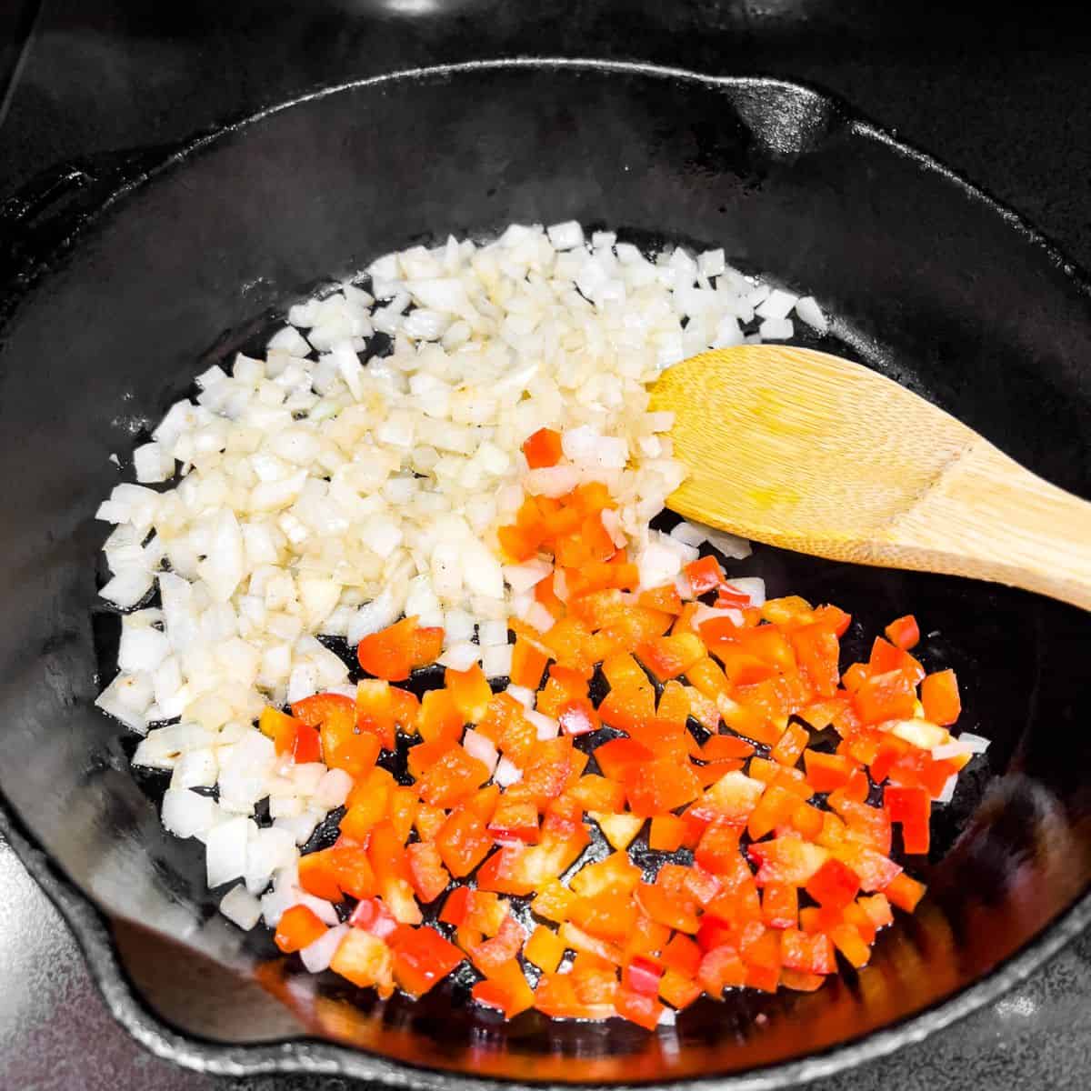 Cooking onion and bell pepper in a skillet.