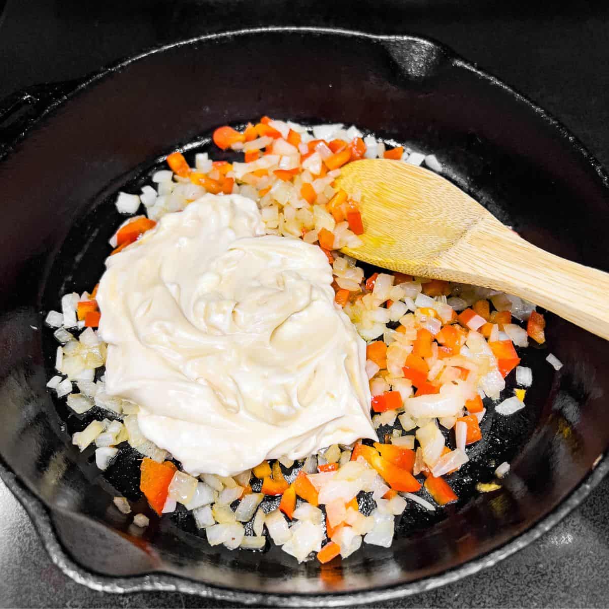 Adding mayonnaise mixture into the skillet.
