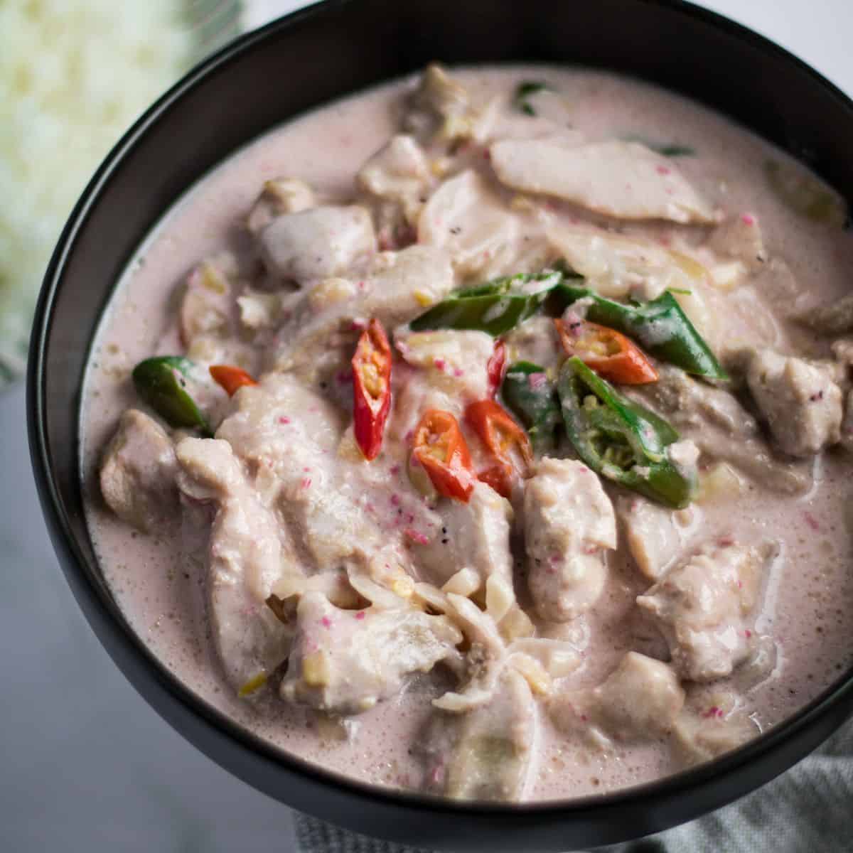 Finish dish of chicken bicol Express in a black bowl.