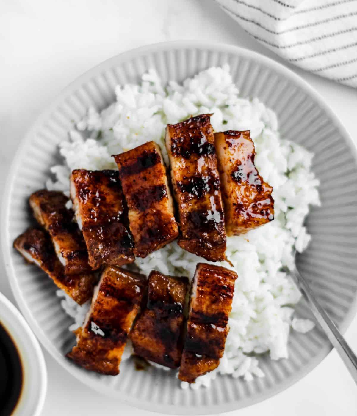 Pork belly liempo with rice on a table.