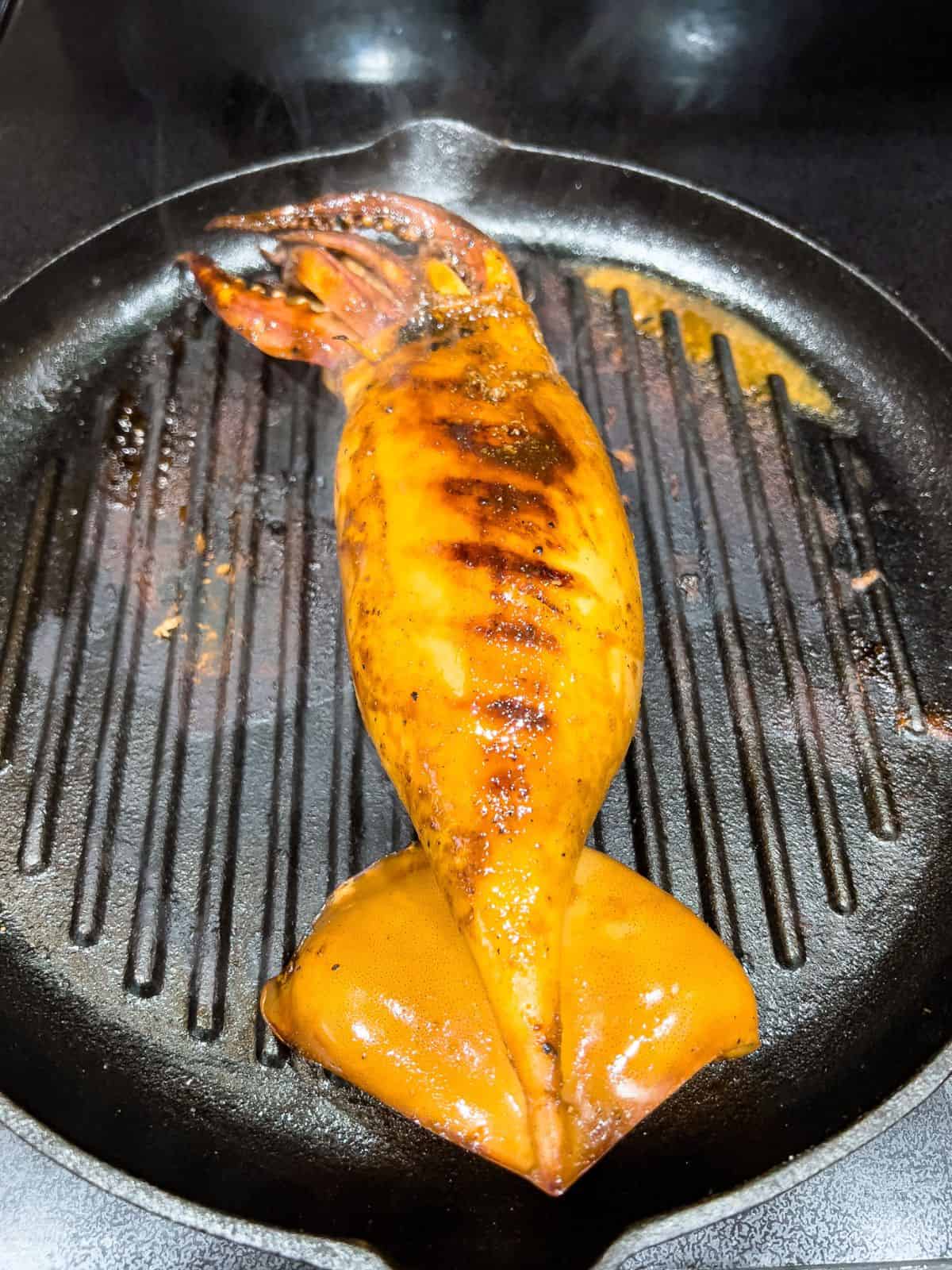 Grilling the squid in a stovetop griller.