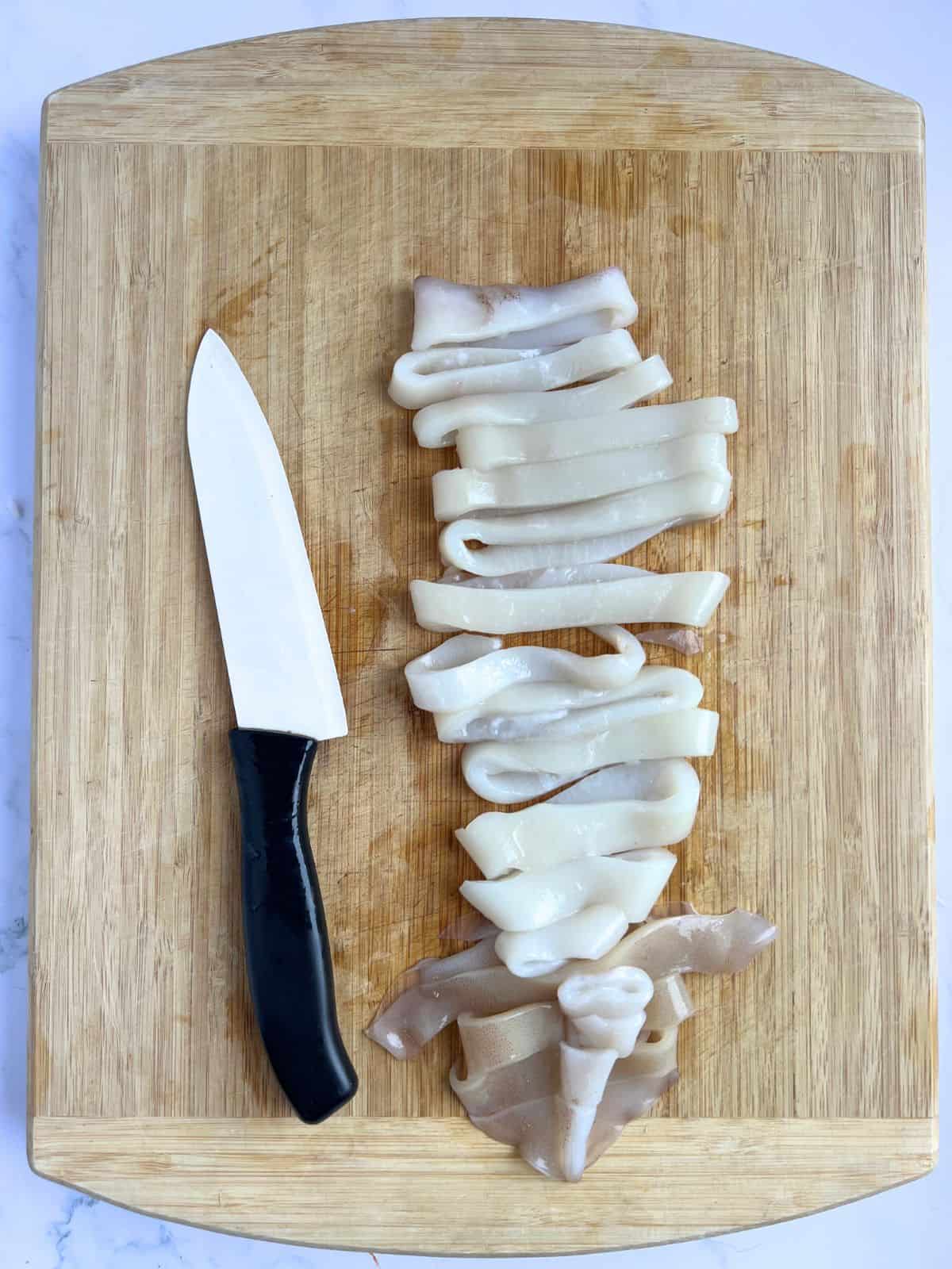 Clean and sliced squid on a chopping board