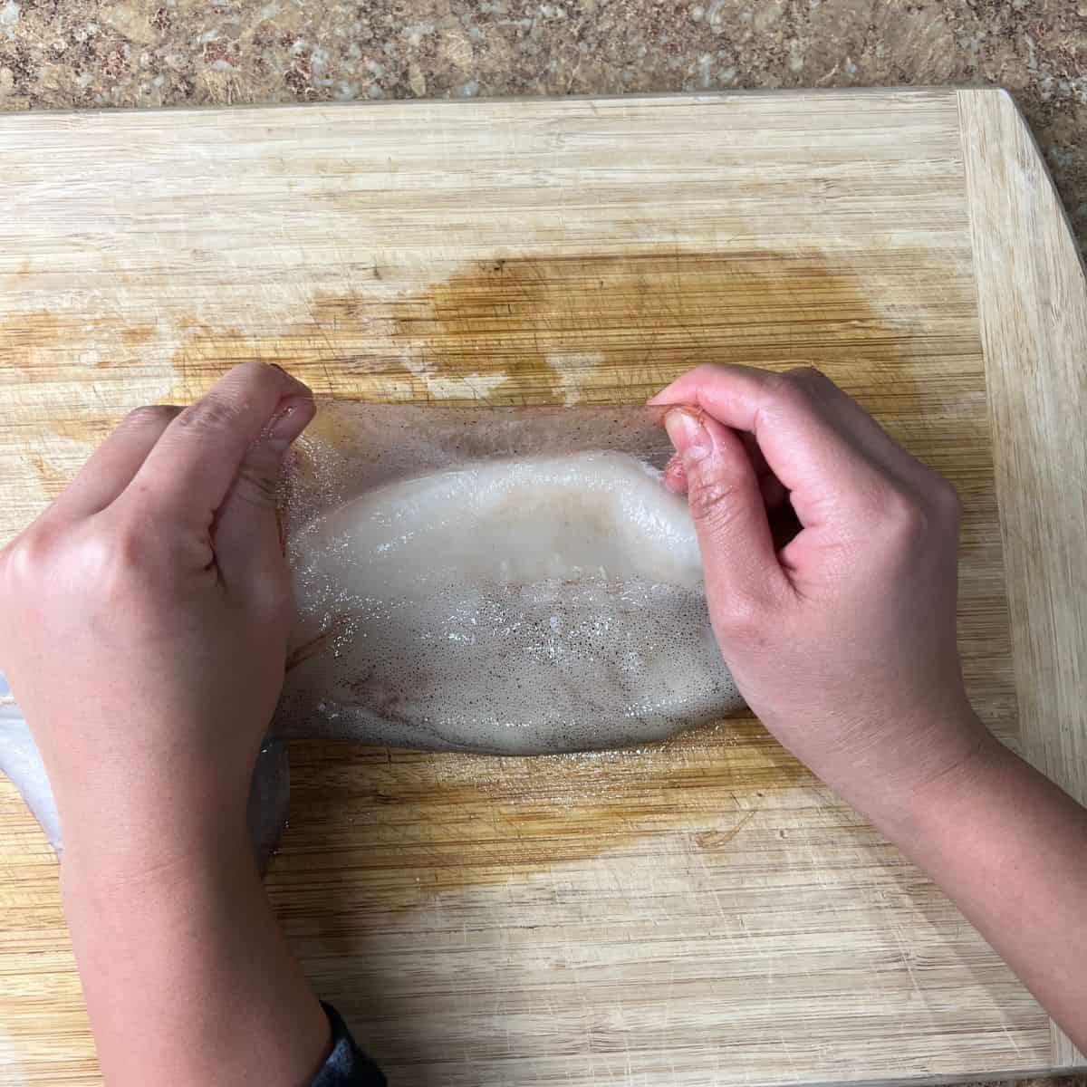 Removing the peel from the squid.