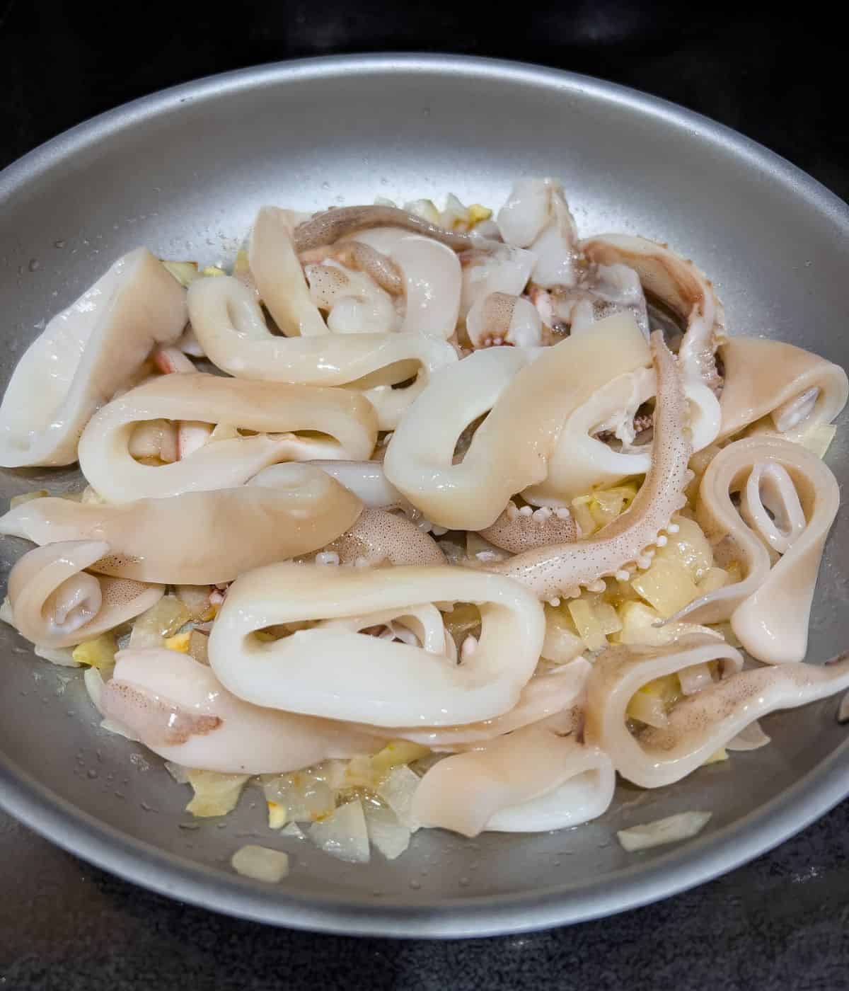 Adding the squid into the skillet.