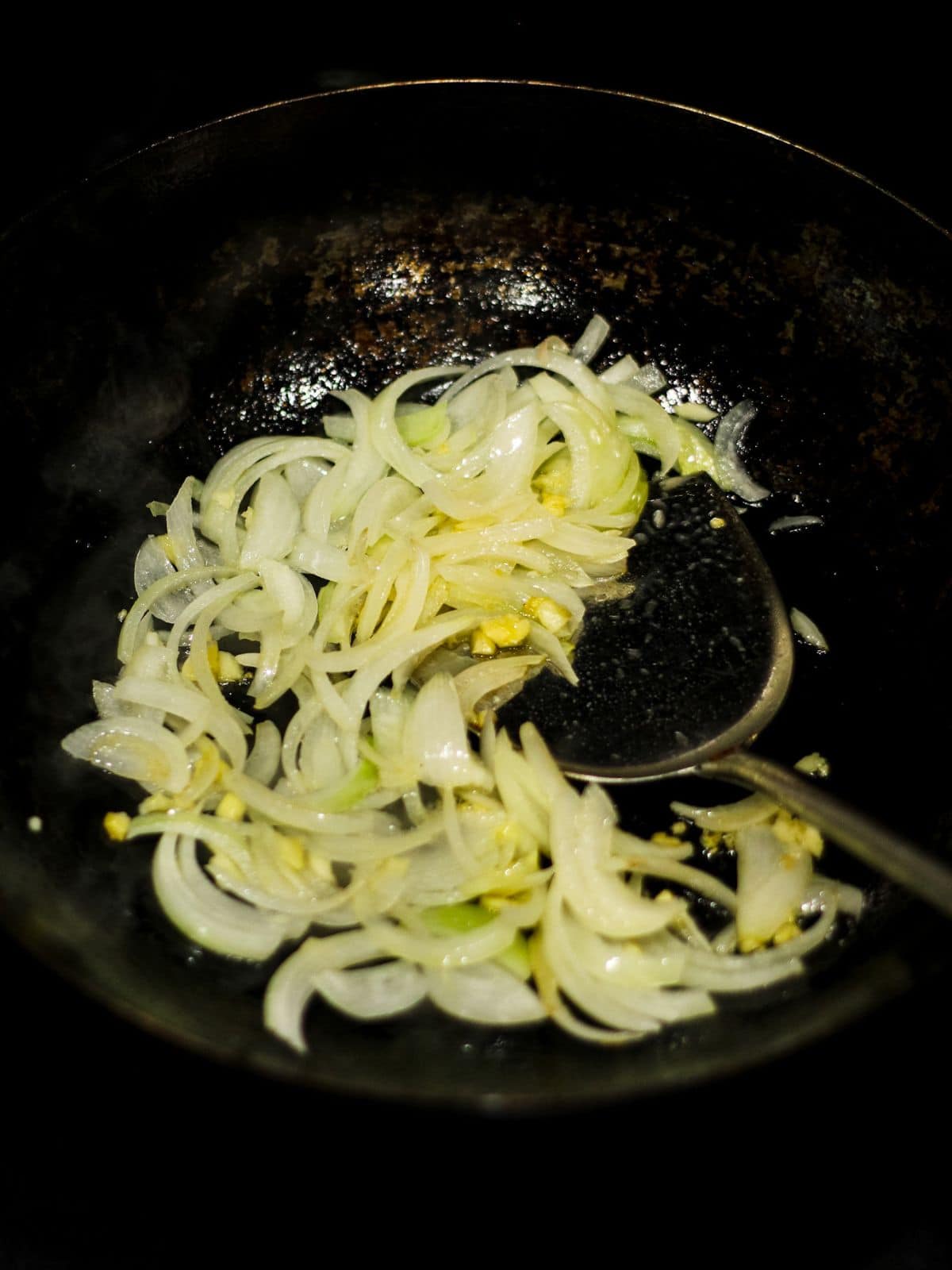 Sauteed onion and garlic in a wok.